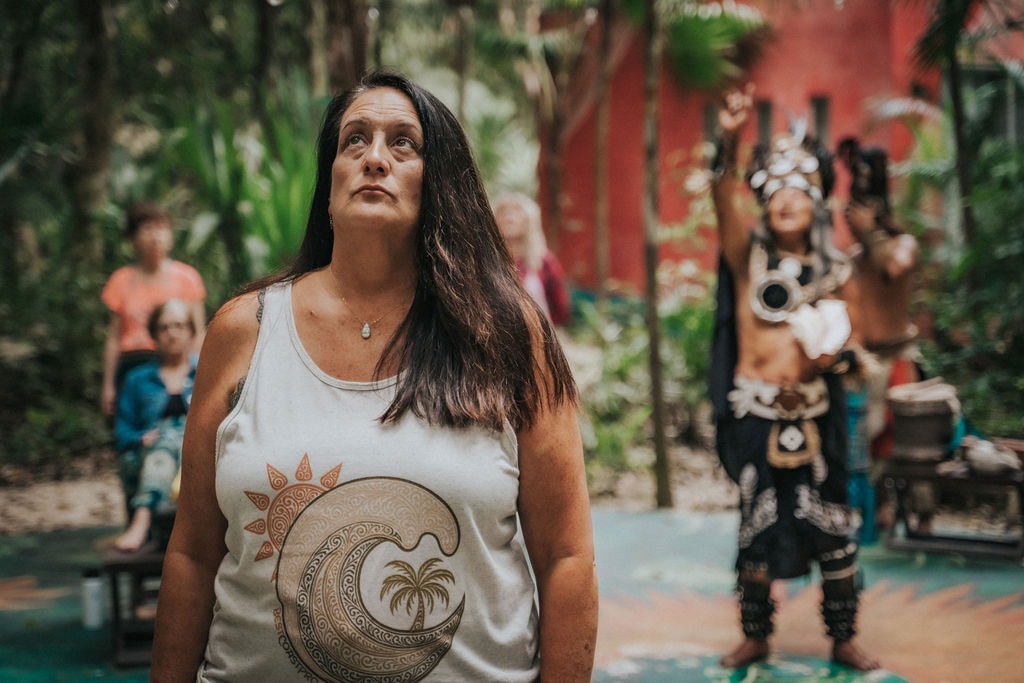 Maureen at a sacred cultural gathering with ceremonial performer
